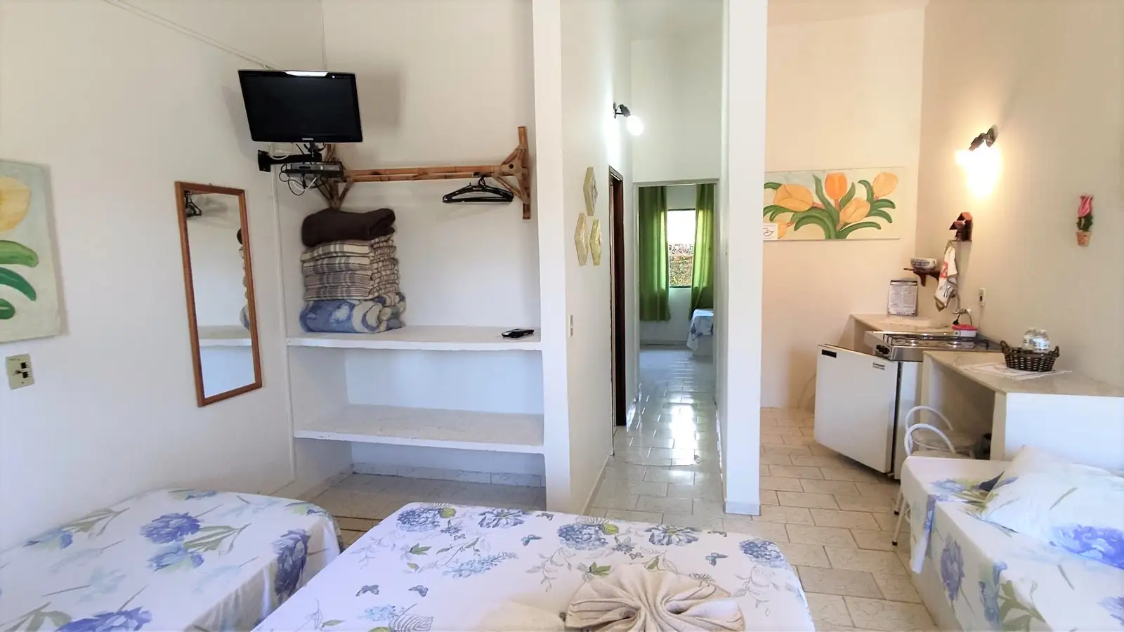 Interior do Chalé Familiar, com TV, espelho e a passagem entre os dois quartos