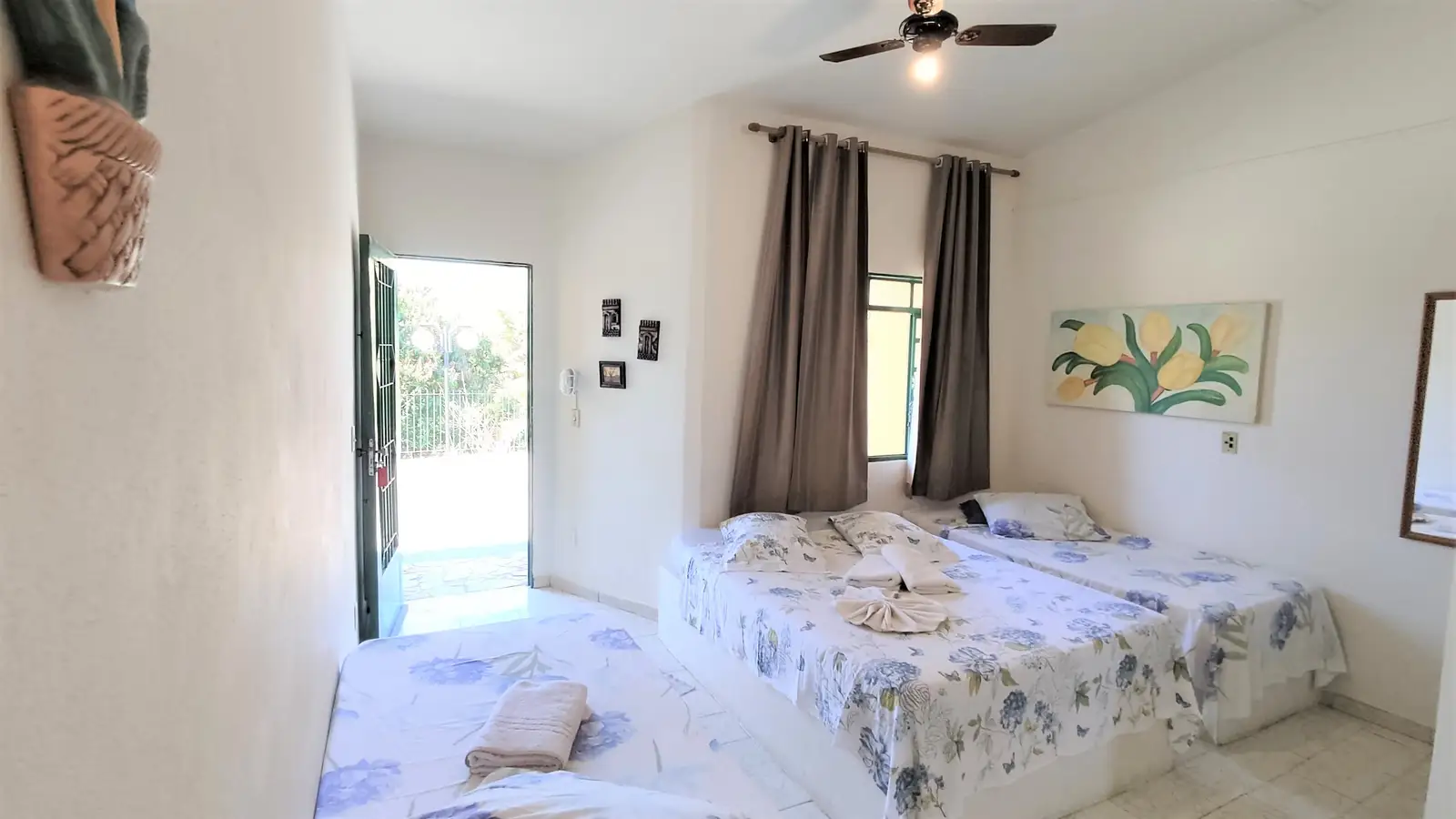 Quarto do Chalé Familiar, com cama de casal e a porta aberta para fora