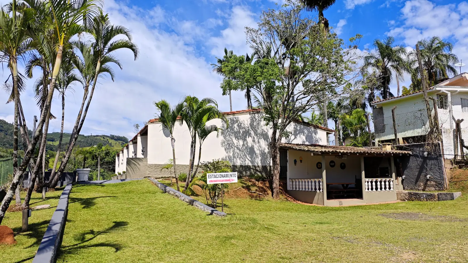 Área verde na frente dos Chalés Familiares, entre palmeiras