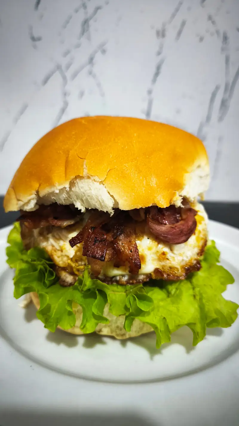 Lanche de hambúrguer com bacon, ovo e salada