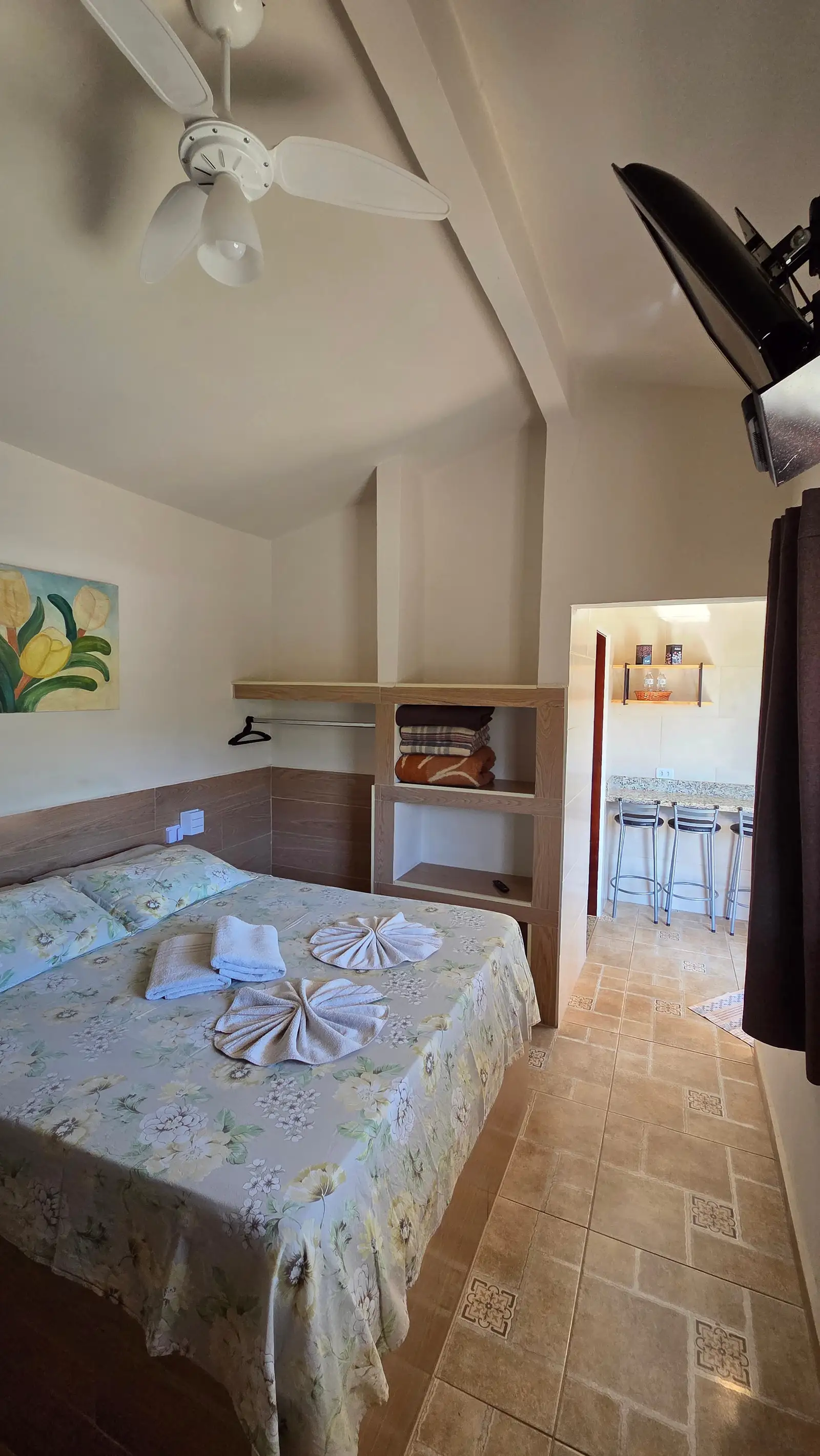 Quarto do Chalé Master, com arara de roupas e a passagem para a cozinha
