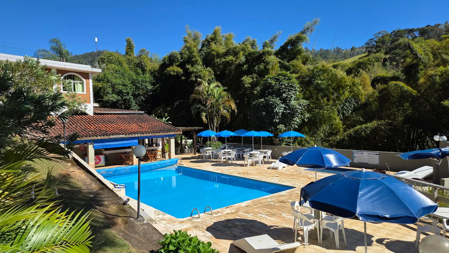 Piscina da pousada com guarda-sóis e espreguiçadeiras