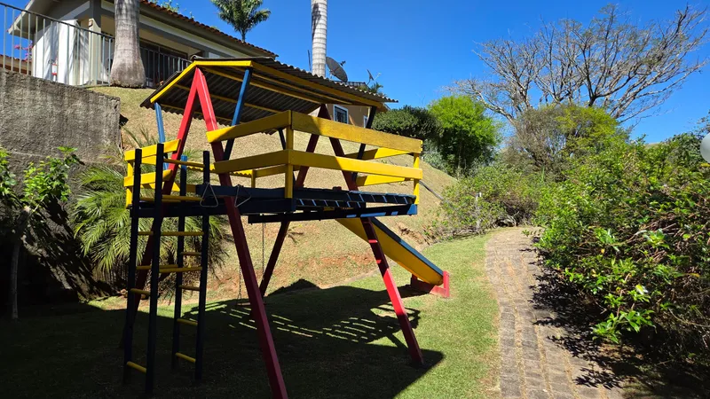 Playground da pousada, com escorregador e gangorra no gramado