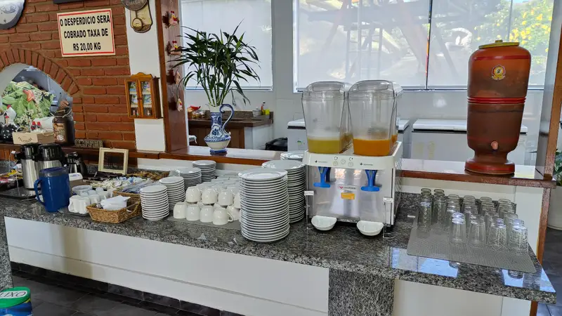 Balcão com sucos, xícaras e pratos empilhados
