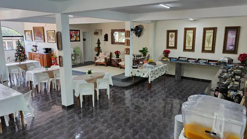 Salão do restaurante com as mesas postas e o buffet ao fundo