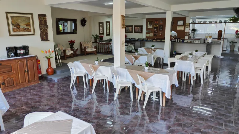 Salão do restaurante da pousada, com as mesas postas