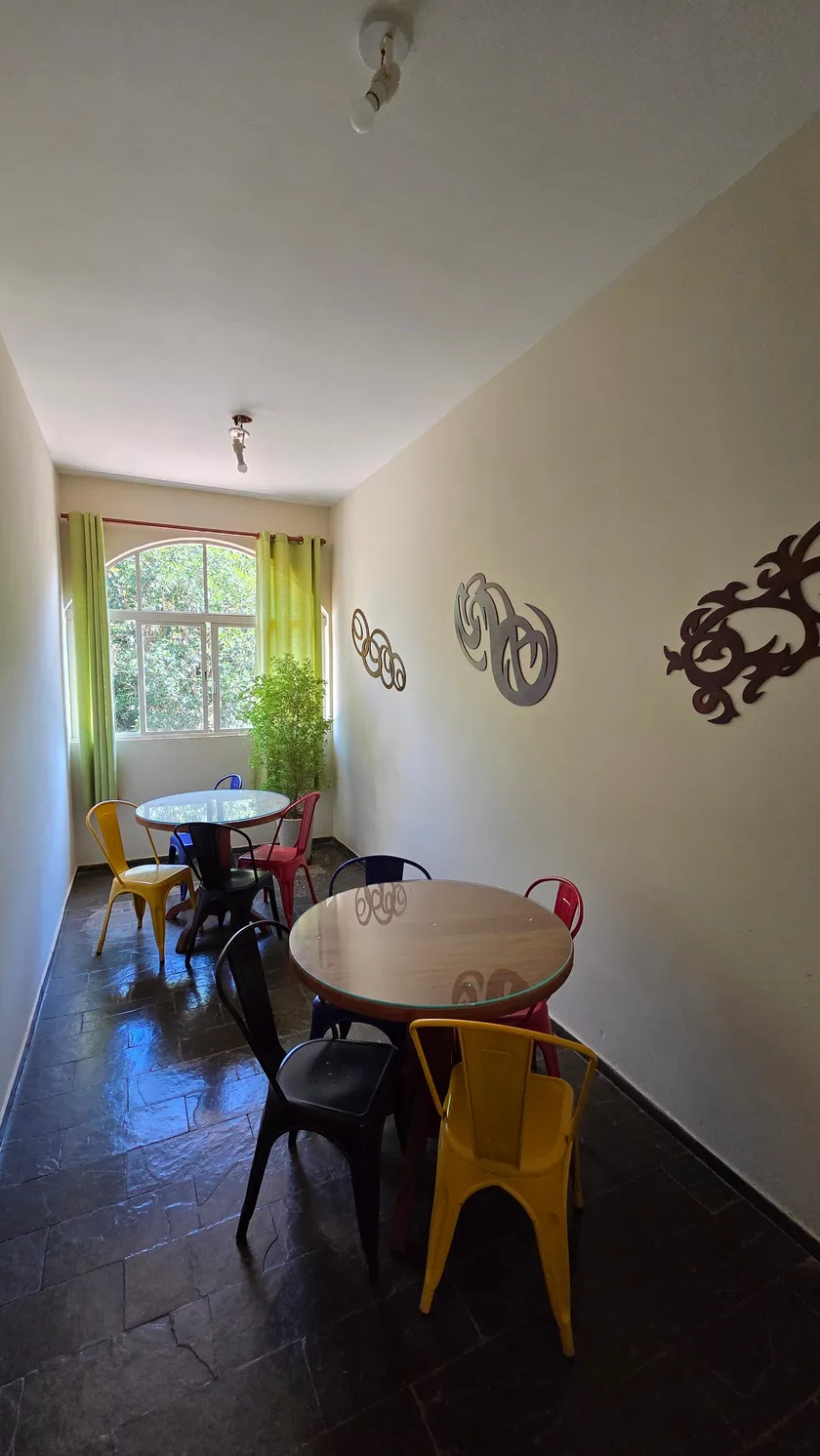 Sala de carteado, com duas mesas redondas e cadeiras coloridas