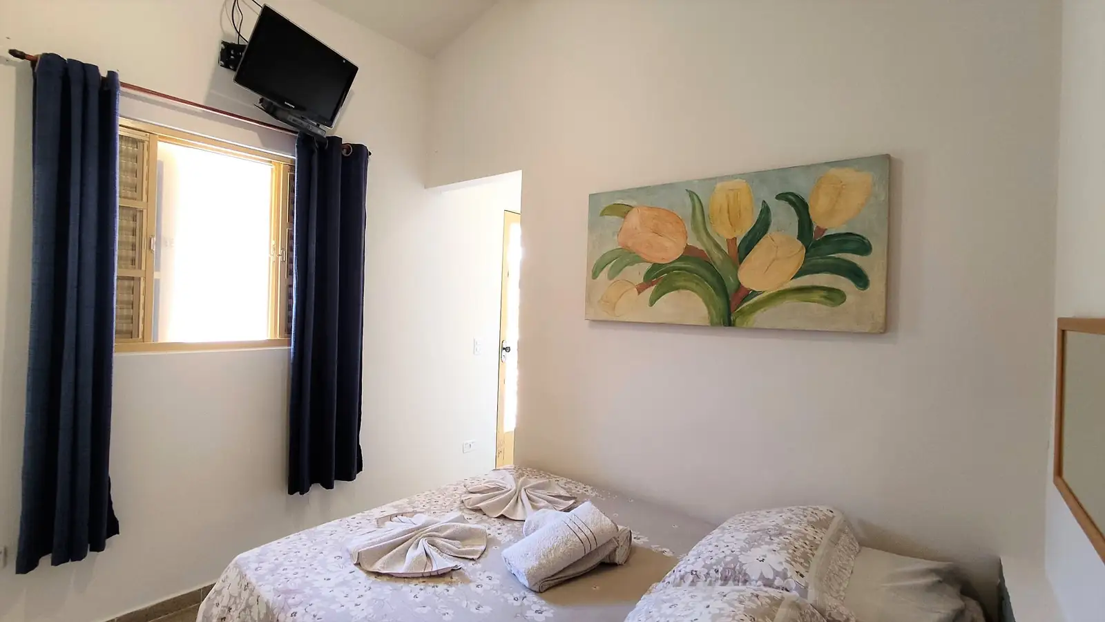 Quarto do Chalé Standard, com cama de casal, TV e quadro na parede
