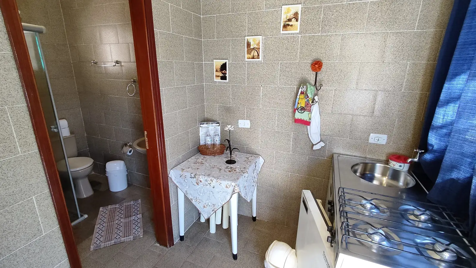 Cozinha do Chalé Standard, com mesa de apoio, pia e a porta do banheiro